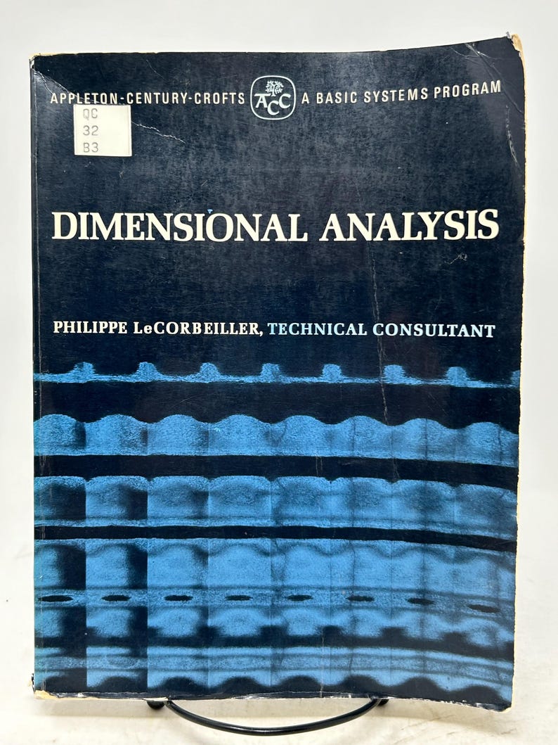 May include: A vintage book titled "DIMENSIONAL ANALYSIS" by Philippe LeCorbeiller. The cover is dark blue with white text and a blue patterned design. The book has a label with the numbers "32" and "B3".