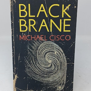 Puede incluir: Un libro de bolsillo titulado Black Brane de Michael Cisco. La portada es negra con el t&iacute;tulo en amarillo y el autor en naranja. Un gr&aacute;fico blanco en forma de espiral arremolinada que recuerda a una galaxia est&aacute; centrado en la parte inferior.