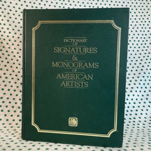 Puede incluir: Un libro de tapa dura verde con letras doradas en el lomo y la portada. El título es "Dictionary of Signatures & Monograms of American Artists".