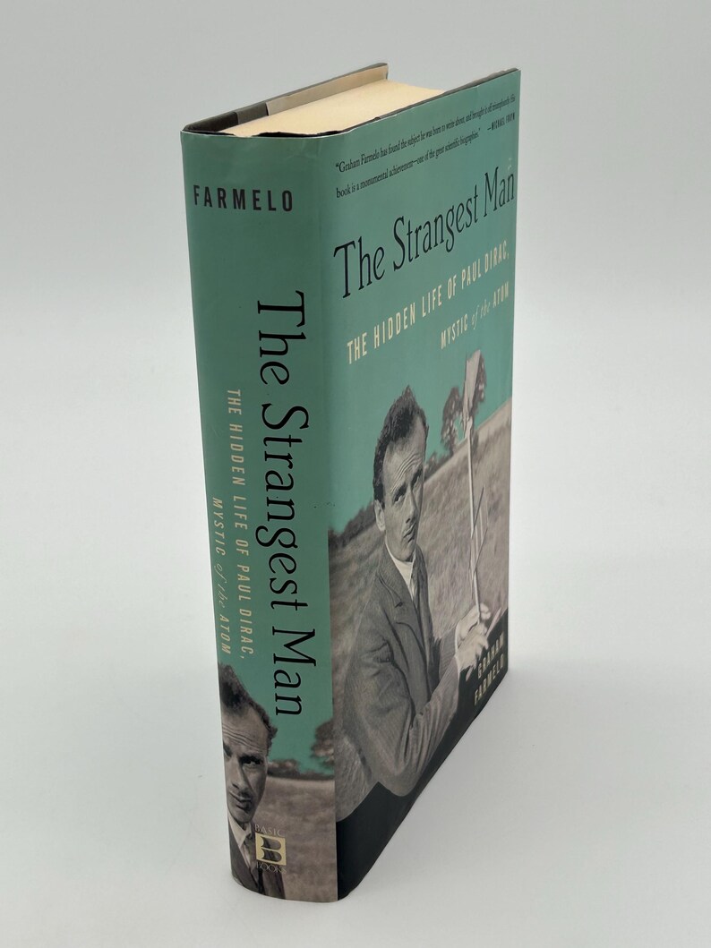 May include: A hardcover book titled "The Strangest Man" by Graham Farmelo. The book has a teal cover with the title in white and the author's name in black. The cover features a black and white image of a man.