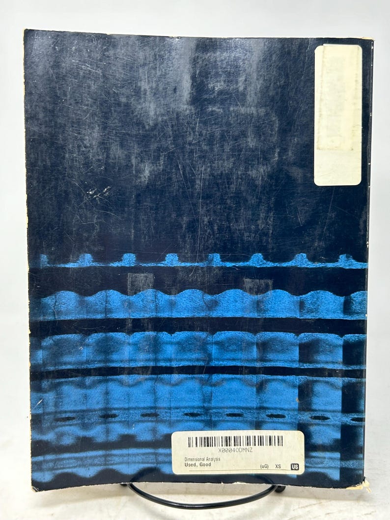 May include: A used book with a dark blue cover featuring a textured design with horizontal blue lines. A white label with text and a barcode is affixed to the cover. The book is titled "Dimensional Analysis".