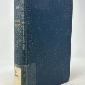 May include: A vintage hardcover book with a dark blue cover. The book's spine displays the title "THERMO DYNAMICS" and the author's name, "LEWIS," in gold lettering. A label with text is affixed to the lower spine. The book's cover shows signs of wear.
