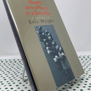 May include: A book titled "Always Give a Penny to a Blind Man: A Memoir" by Eric Wright. The cover features a black and white photograph of children holding cups.