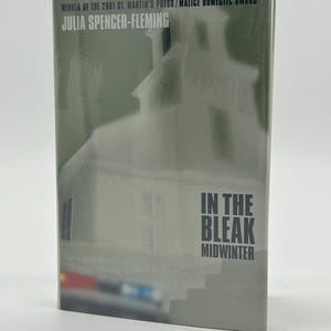 Może przedstawiać: Okładka książki "In the Bleak Midwinter" autorstwa Julii Spencer-Fleming. Okładka przedstawia szary obraz budynku, prawdopodobnie kościoła, z tytułem i nazwiskiem autora pogrubioną czcionką. Widoczny jest również tekst "WINNER OF THE 2001 ST. MARTIN'S PRESS/MALICE DOMESTIC AWARD".