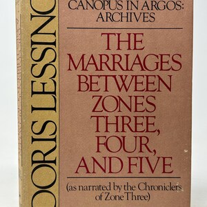 May include: A vintage book titled "The Marriages Between Zones Three, Four, and Five" by Doris Lessing. The cover features a tan and pink color scheme with black and red text. The book is part of the "Canopus in Argos: Archives" series.