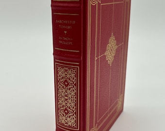 Puede incluir: Un libro de tapa dura rojo titulado "Barchester Towers" de Anthony Trollope. El libro tiene detalles decorativos y texto dorados. El lomo y la cubierta presentan patrones dorados ornamentados.