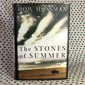 May include: A book cover with a cloudy sky and a car driving on a dirt road. The title of the book is "The Stones of Summer" by Dow Mossman.