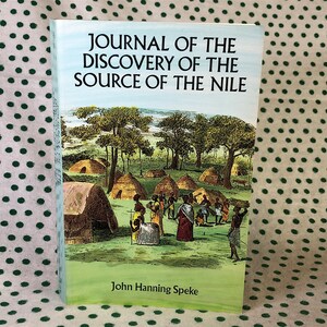 May include: A vintage book titled "Journal of the Discovery of the Source of the Nile" by John Hanning Speke. The cover features an illustration of a village in Africa with people and huts.