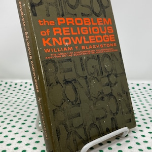 May include: A green book titled "The Problem of Religious Knowledge" by William T. Blackstone. The cover features the word "Religion" in large, overlapping letters.