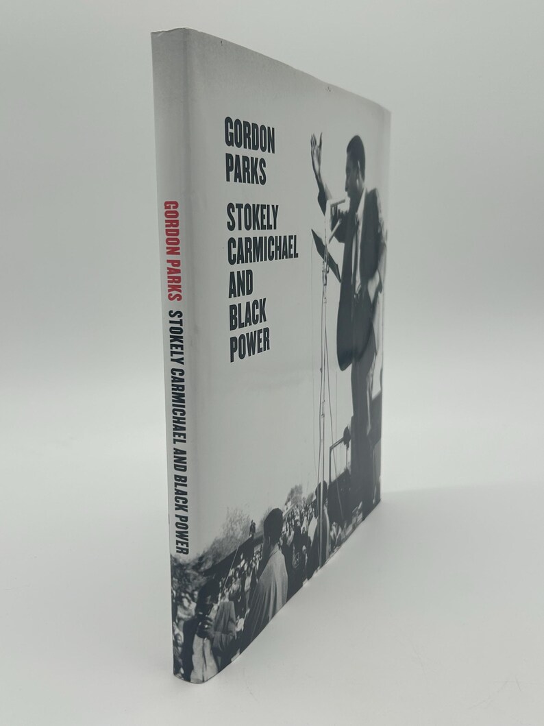 May include: A hardcover book titled "Gordon Parks, Stokely Carmichael and Black Power." The cover features a black and white photograph of a man speaking at a podium with a crowd in the background. The book's spine also displays the title.