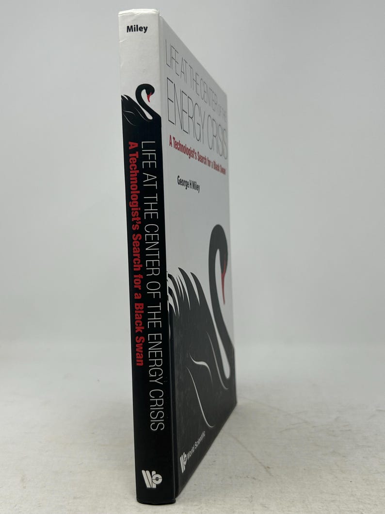 May include: A book titled "LIFE AT THE CENTER OF THE ENERGY CRISIS" by George R. Miley. The cover features a black swan illustration with red accents. The spine displays the author's name and the book's title, with the publisher's logo at the bottom.