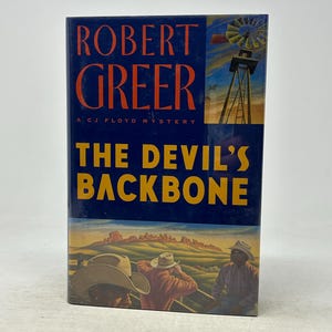 Könnte beinhalten: Ein Hardcover-Buch mit dem Titel "The Devil's Backbone" von Robert Greer. Das Cover hat einen blauen Hintergrund mit dem Titel in Gelb und dem Namen des Autors in Orange. Das Cover zeigt eine Windmühle und drei Personen mit Cowboyhüten.