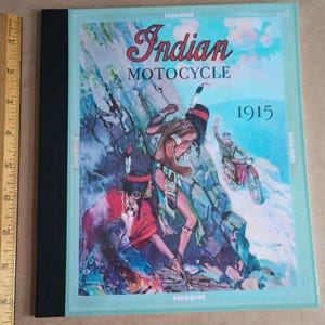 Peut inclure: Une publicité vintage pour Indian Motorcycle datant de 1915. La publicité met en scène deux personnages amérindiens vêtus de vêtements traditionnels conduisant une moto à travers un paysage rocheux. Le texte "Indian Motorcycle" et "1915" est affiché en évidence.