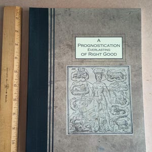 Könnte beinhalten: Ein Buch mit dem Titel "A Prognostication Everlasting of Right Good" mit schwarzem Rücken und einer Vintage-Illustration einer menschlichen Figur mit Tierkreiszeichen auf beigefarbenem Hintergrund.