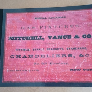 May include: A vintage catalog cover with a red background and black text. The text reads "SPECIAL CATALOGUE GAS FIXTURES MITCHELL, VANCE & CO.," listing fittings, chandeliers, and other gas-related items. The catalog is bordered in black.