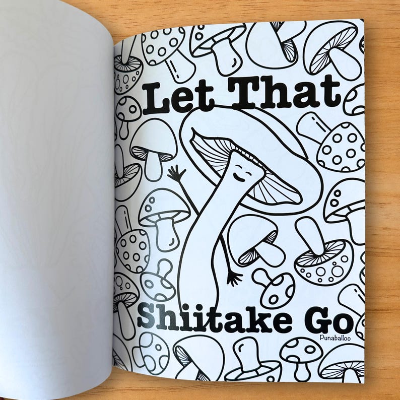 Puede incluir: Una p&aacute;gina de libro para colorear en blanco y negro con ilustraciones de hongos. El texto "Let That Shiitake Go" se muestra en negrita, con una fuente estilizada. La p&aacute;gina est&aacute; abierta, revelando una p&aacute;gina en blanco a la izquierda.