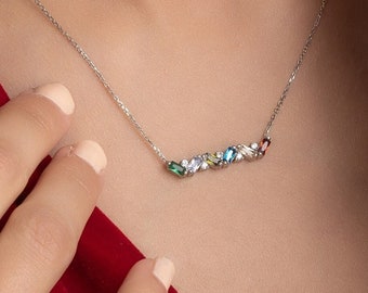 May include: A silver necklace with a delicate chain and a row of colorful gemstones. The gemstones are arranged in a line and are of various shapes and sizes.