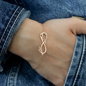 Puede incluir: Un brazalete de infinito de oro rosa con los nombres "Gloria" y "Joseph" grabados en él.