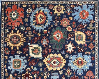 May include: A large, rectangular area rug with a dark blue background and an intricate pattern of floral and geometric designs in shades of red, blue, yellow, and green. The rug has a detailed border.