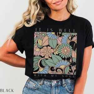May include: Black t-shirt with a floral design and the text "It is well with my soul".