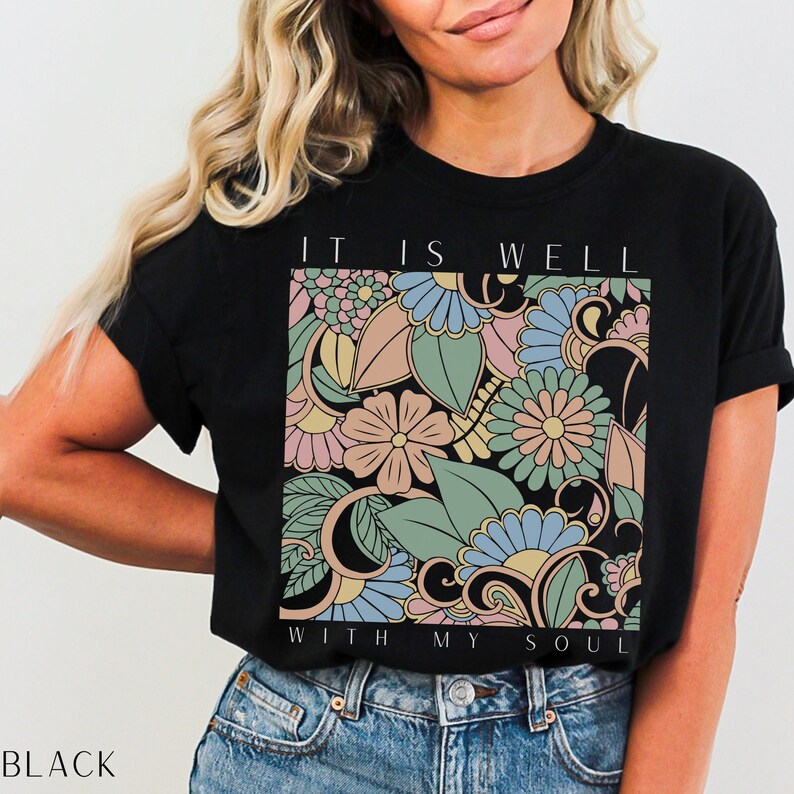 May include: Black t-shirt with a floral design and the text "It is well with my soul".