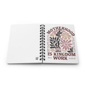 May include: A spiral bound journal with a white cover and a floral design. The text on the cover reads "Motherhood is Kingdom Work Prov. 31:25-27".