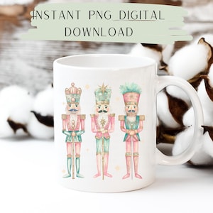 May include: White ceramic mug with a design of three pink and green nutcracker soldiers. The nutcrackers are standing in a row and have gold accents. The mug has a handle on the right side.