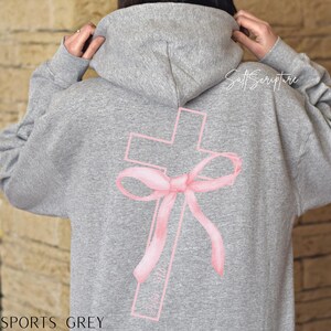 May include: A sports grey hoodie featuring a pink cross design with a bow. The text "Salt Scripture" is printed on the upper right side of the hoodie. The words "Sports Grey" are printed at the bottom of the hoodie.