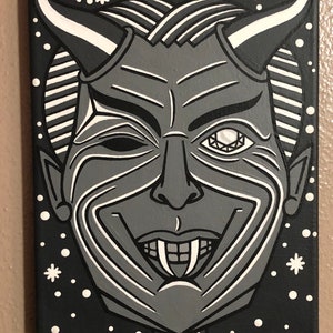 May include: A black and white painting of a devilish face with a single white eye and a toothy grin. The background is black with white stars.