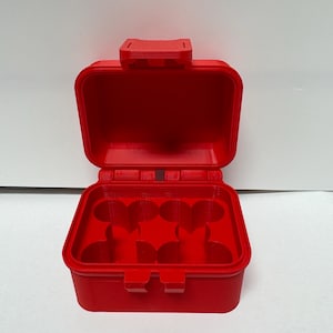 May include: A bright red, rectangular plastic storage case with a hinged lid and a secure latch mechanism. The interior features four circular, clover-shaped compartments designed for organizing small items, with a textured finish on the exterior.