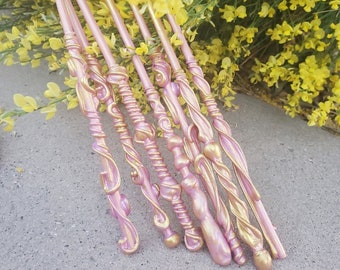 以下が含まれることがあります： 複雑なデザインが施されたピンクとゴールドの杖が8本セットになっています。杖は滑らかで光沢のある素材で作られており、先端が尖っています。