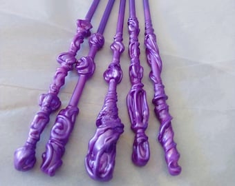 May include: Five purple wands with intricate designs. The wands are made of a smooth, shiny material and have a pointed tip.