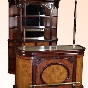 May include: A traditional wooden bar unit with a curved front, a marble countertop, and a mirrored back. The unit has a dark wood finish and intricate carvings.