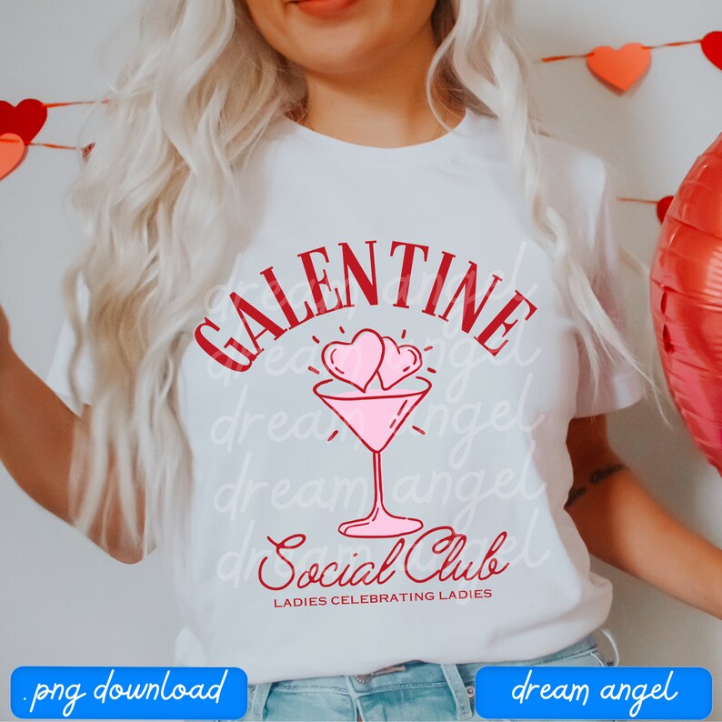 May include: White t-shirt with red text that says "Galentine Social Club" with two pink hearts above a martini glass. The text below the martini glass says "Ladies Celebrating Ladies".