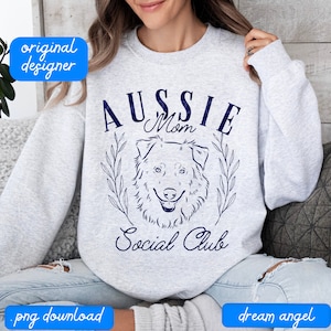 May include: A gray sweatshirt with a blue graphic design that says "Aussie Mom Social Club" with a line drawing of an Australian Shepherd dog's head.