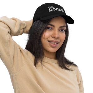 Puede incluir: Una gorra de béisbol negra con bordado blanco que dice "[make more] bonsai".