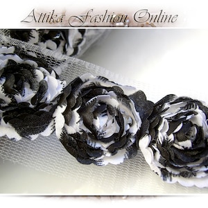 May include: Black and white floral trim with a mesh backing. The trim features a repeating pattern of large, layered fabric flowers.