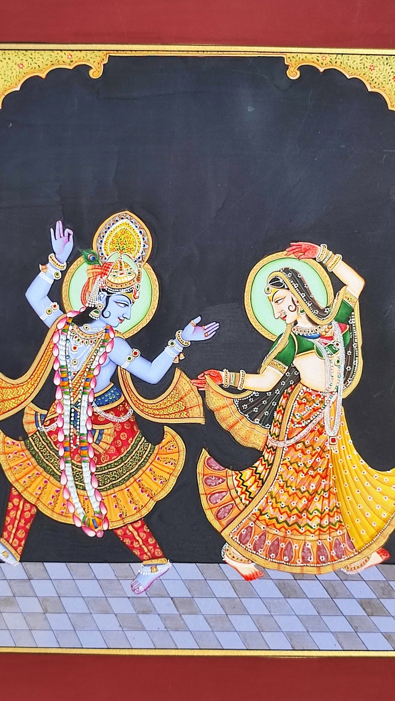 May include: A painting on a black background depicting two figures dancing. The figure on the left has blue skin, wears a crown with a peacock feather, and is adorned with jewelry and a floral garland. The figure on the right wears a green and yellow patterned dress with jewelry.