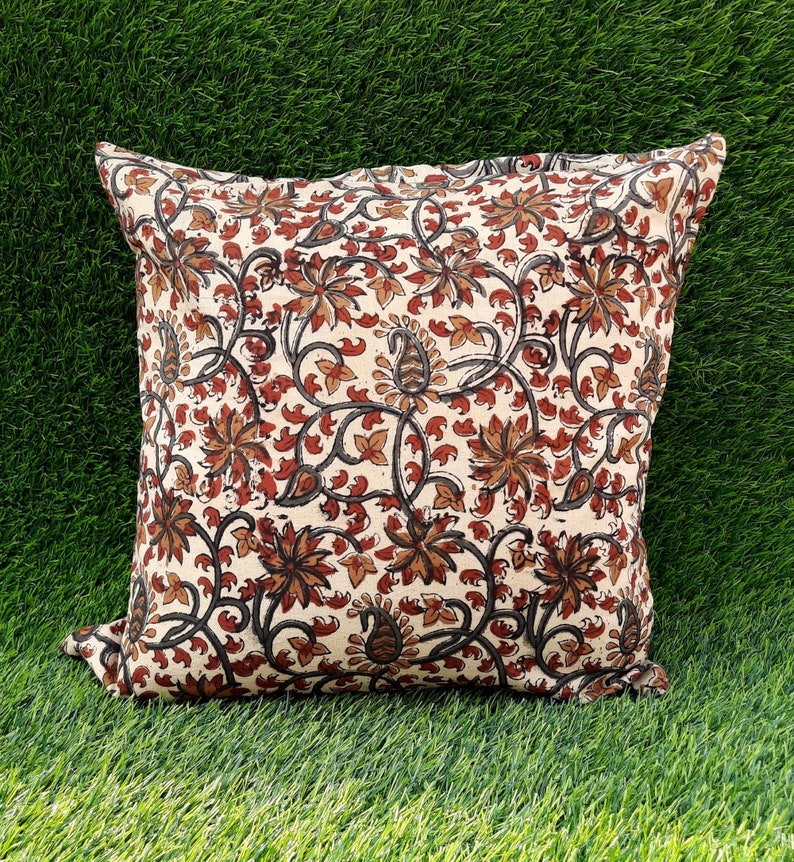 May include: A cream-colored pillow cover with a floral pattern in shades of brown and red. The pillow cover features a repeating design of stylized flowers and leaves.