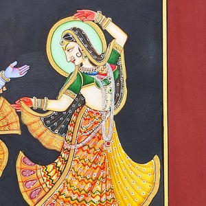 May include: A painting on a black background featuring a figure in a green blouse and a yellow patterned skirt with red and white details. The figure wears jewelry, a headpiece, and a light green halo, standing on a gray and white tiled floor.