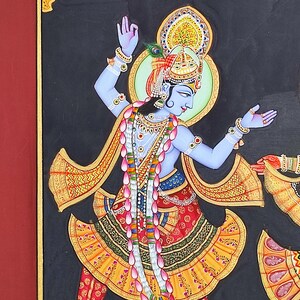 May include: A painting on a black background depicting a blue-skinned figure in a dynamic dancing pose. The figure wears an ornate gold crown, a yellow and red patterned skirt, and a long garland of pink lotus flowers over a bare chest.