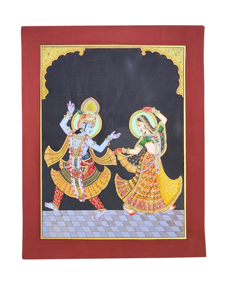 May include: A rectangular painting in a dark red frame depicting two figures dancing on a checkered floor against a black background. The blue-skinned figure wears a crown and yellow garments, while the other figure wears a green top and yellow skirt.
