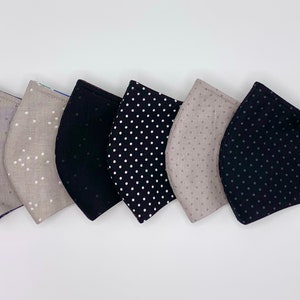 May include: Six face masks with different patterns. Three are black with white polka dots, two are beige with white polka dots, and one is solid black.