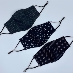 May include: Three black face masks with different silver patterns. The masks have adjustable ear loops. The patterns include small silver dots, larger silver dots, and thin silver lines.