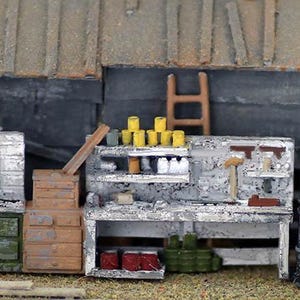 May include: A miniature model of a workshop with a workbench, shelves, and tools. The workbench has a wooden top and metal legs. The shelves are filled with various items, including paint cans, tools, and other supplies. The workshop is made of wood and painted in a realistic style.