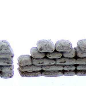 May include: Two sets of miniature sandbag fortifications, made of gray painted resin, for use in wargaming or model railroading. The larger set has 10 sandbags, while the smaller set has 7 sandbags.