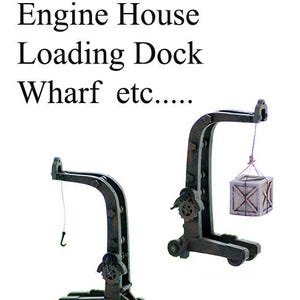 May include: Two miniature portable cranes in a dark, weathered finish. One crane has a hook, the other lifts a small wooden crate. Text at the top reads "Warehouse Engine House Loading Dock Wharf etc...." and "Portable CRANE" at the bottom.