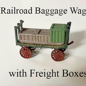 May include: A miniature model of a railroad baggage wagon with freight boxes. The wagon is green and brown with red wheels. The wagon is on a white surface.