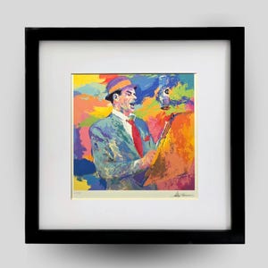 May include: A framed art print featuring a colorful, impressionistic painting of a singer in a hat and suit, holding a microphone and sheet music. The background consists of vibrant, abstract brushstrokes in yellow, blue, and orange hues.