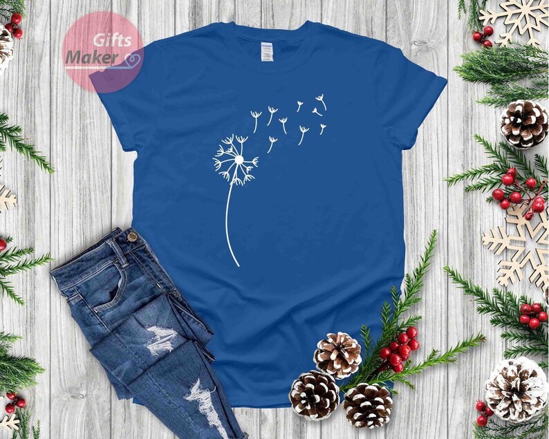 May include: A royal blue t-shirt with a white dandelion design. The dandelion has seeds blowing in the wind.